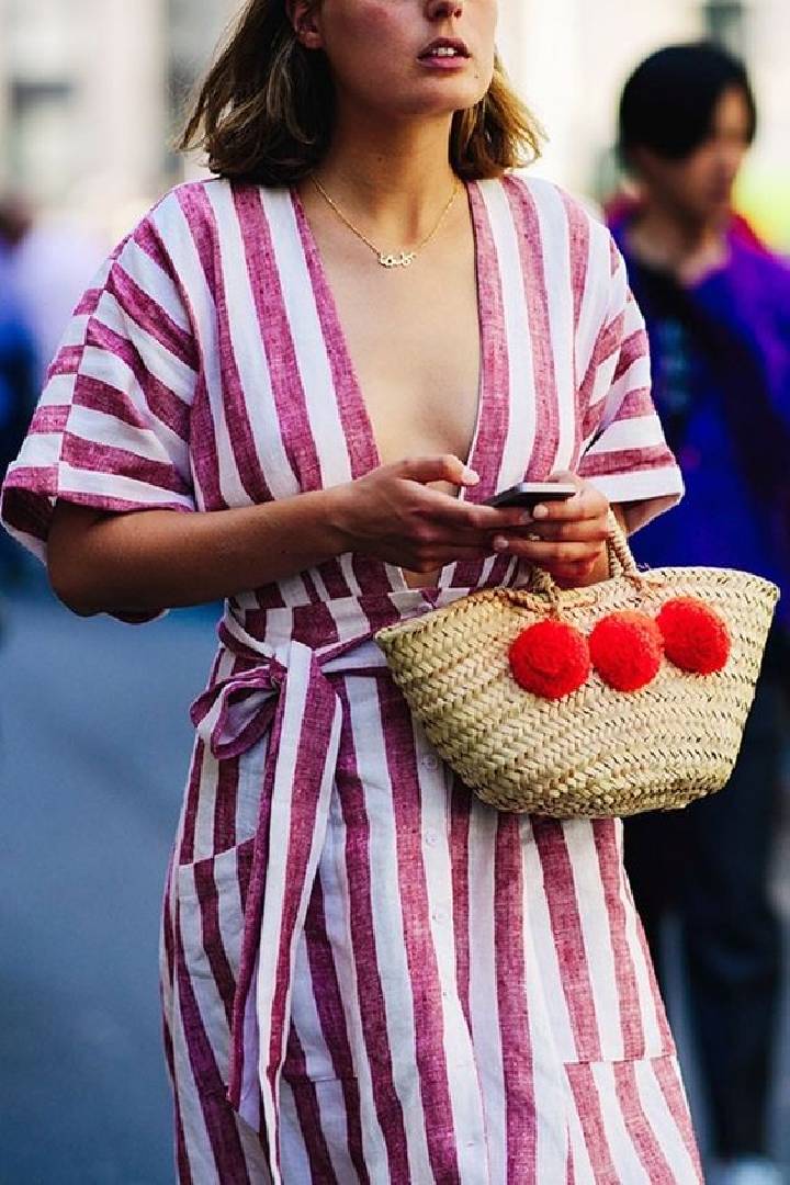 un sac en forme de panier avec de grands pompons rouges 