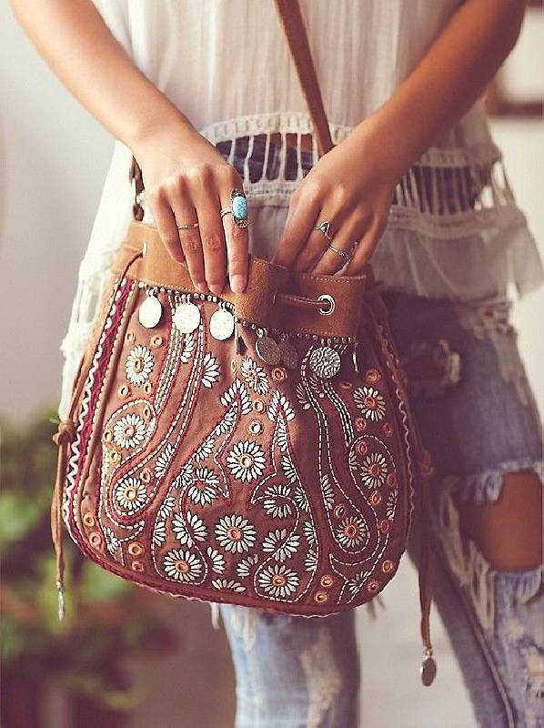 un sac bohème en cuir brun décoré de perles, de broderies et de pièces de monnaie