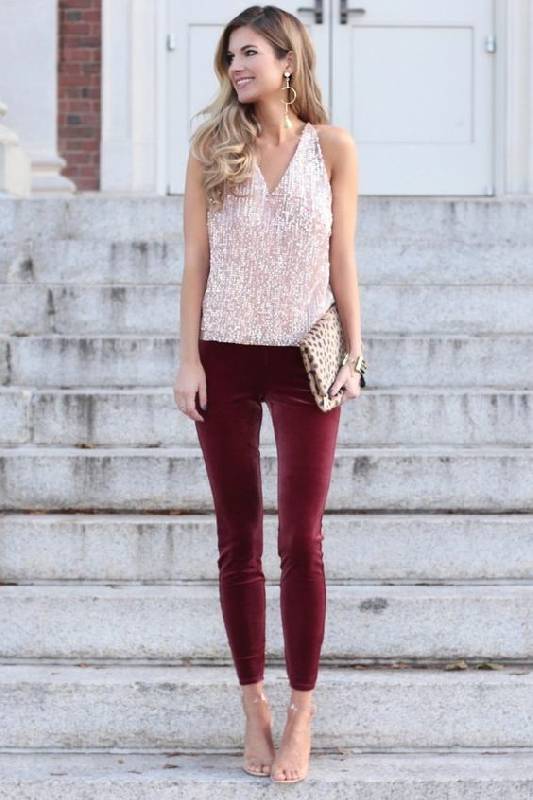 un look de vacances avec un haut à paillettes roses, un pantalon en velours bordeaux, des chaussures nues et une pochette à motifs d'animaux